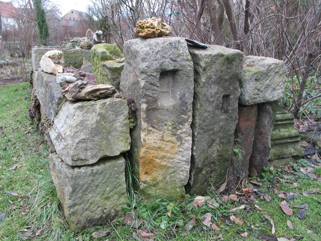 Aus alten Sandsteinen, die aus dem Bauschutt der umliegenden Dörfer zusammengetragen worden entstand eine Trockenmauer.