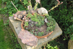 Alte Sandsteine bilden an vielen Stellen im Garten Beeteinfassungen und Säulen.